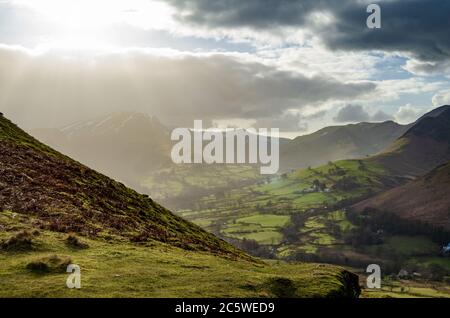Sunny and hazy view from Catbells in Lake District, showing a village and near mountains and hills Stock Photo