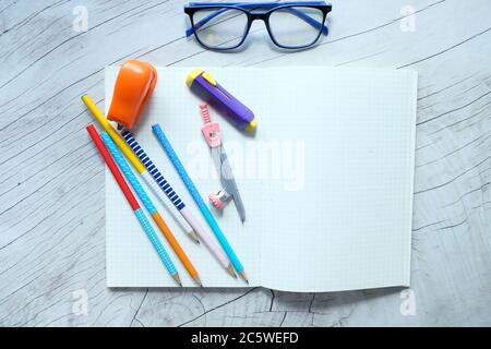 Blank notebook and school supplies on wooden table . Stock Photo