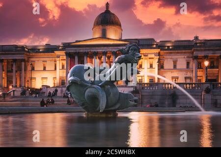 Fountain at Trafalgar Square and the National Gallery in London illuminated at night