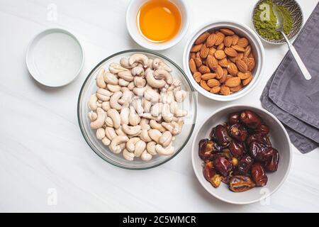 Ingredients in bowls for cooking raw vegan cake with nuts, dates and matcha tea. Healthy vegan food concept. Stock Photo