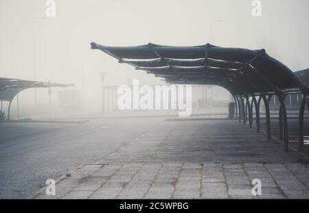 View of a foggy empty covered car parking area inside of a typical filling station zone of Portugal; a parking lot with an overhang on a misty morning Stock Photo