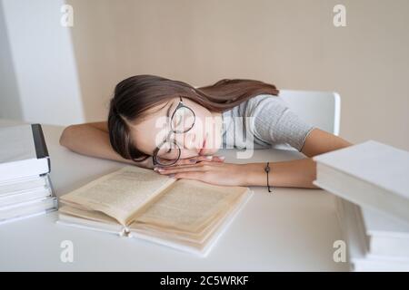 Cute teenager girl fell asleep on the books when she did her homework Stock Photo