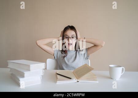 Cute teenage girl tired of studying and doing her homework. Tired and despair student Stock Photo