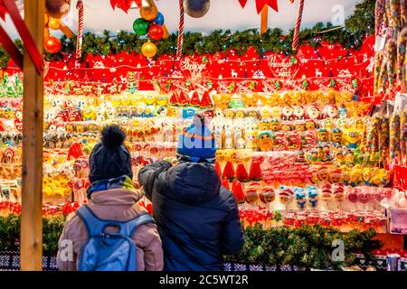 Warsaw, Poland - December 19, 2019: Old town Warszawa Christmas market selling candy sweets and young children kids people shopping wanting food Stock Photo