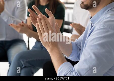 People sit on chairs clapping hands close up image Stock Photo