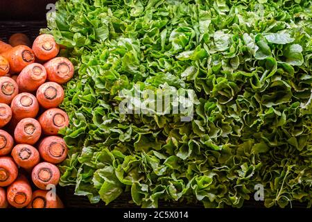 Carrots and Salad Leaves For Sale on a Farmers Market Stall Stock Photo