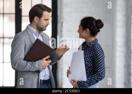 Diverse office colleagues met in office talking discussing project ideas Stock Photo