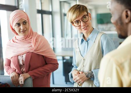 Portrait of modern multi-ethnic business team discussing work project in conference room, focus on short-haired female manager talking to colleagues Stock Photo