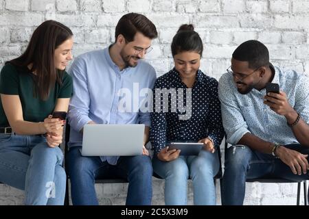 Multiethnic millennial people communicating and using gadgets Stock Photo