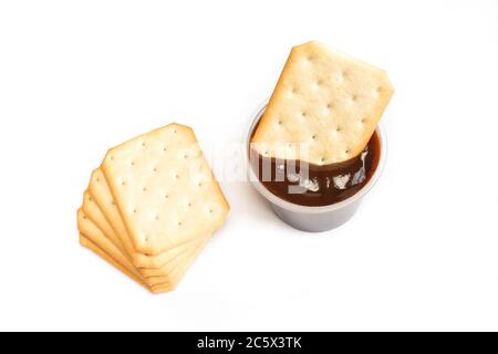 Stack of salted crackers on white background. Biscuit dipped in barbecue sauce inside of plastic package Stock Photo