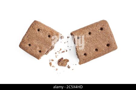 Broken double biscuit and crumbs isolated on white background. Tasty chocolate snack with filling Stock Photo