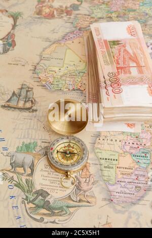 Compass with a bundle of big money are on the map Stock Photo