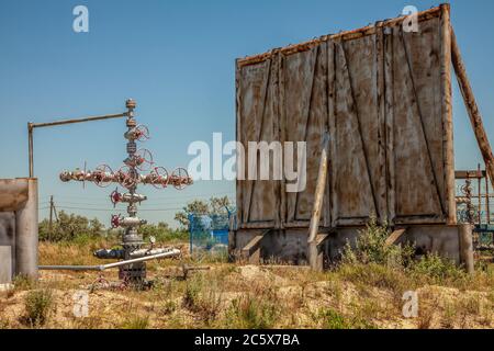 Canned oil is good against the sky, field and torch. Oil well equipment. Shutoff valves and service equipment. Stock Photo