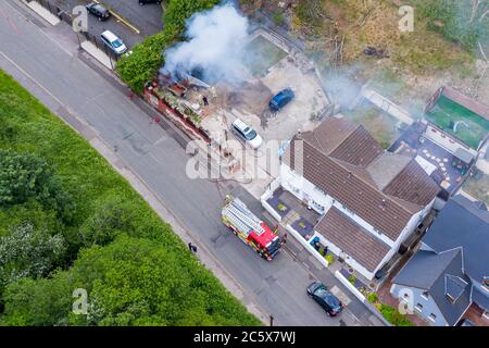 EBBW VALE, WALES, UK - JUNE 26 2020: Aerial view of firefighters tackling a small blaze in a domestic outbuilding. The fire was extinguished within mi Stock Photo