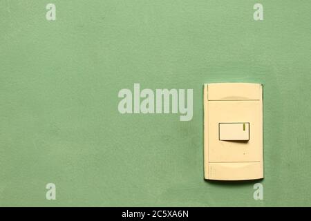 white power switch on a light green wall. with negative space Stock Photo