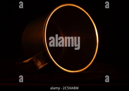 aluminum mug, circular detail with warm light and dark background. minimalist and elegant Stock Photo