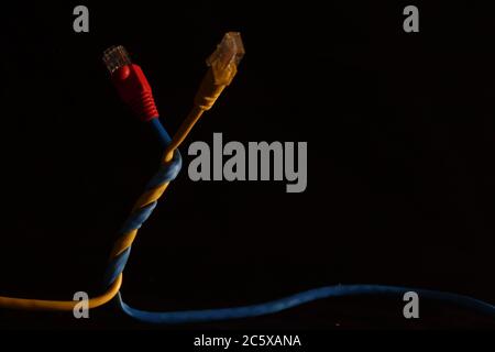 Two network cables with j45 connector made of primary colors yellow, blue and red Stock Photo