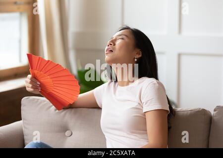 Exhausted young vietnamese biracial woman suffering from heat stroke. Stock Photo