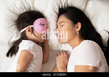 Tranquil mommy sleeping with cute baby girl. Stock Photo