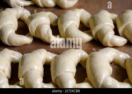 Ready to bake, raw Argentine croissants, medialunas de Manteca over silicon pastry mat background Stock Photo