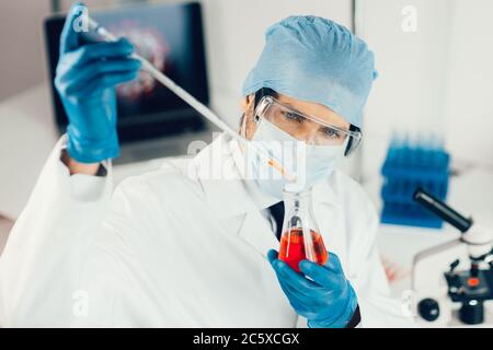 close up. the scientist carefully looking at the test tube . Stock Photo