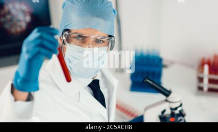 close up. the scientist carefully looking at the test tube . Stock Photo