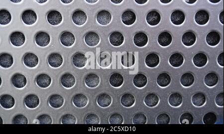 Silver, grey metal background with black holes, metal mesh Stock Photo