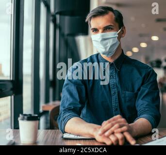 business colleagues in protective masks working with financial documents. Stock Photo
