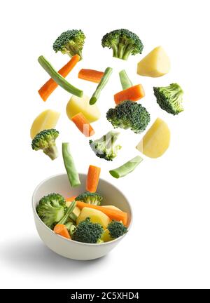 Boiled vegetables flying on white background, green bean, broccoli, potato, carrot. Creative concept Stock Photo