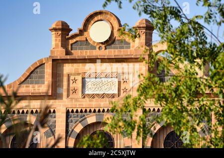 The facade of the main building of Medina railway station, showing the plaque plate with city name (Al Madinah Al Munawwarah) engraved in Arabic  . Stock Photo