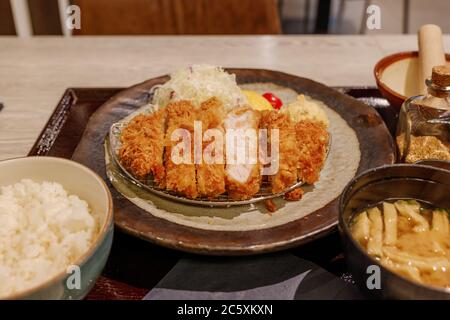 Selected focus at Tonkutsu menu, Japanese deep fried port serve with rice and Miso soup, on table in Japanese restaurant. Stock Photo