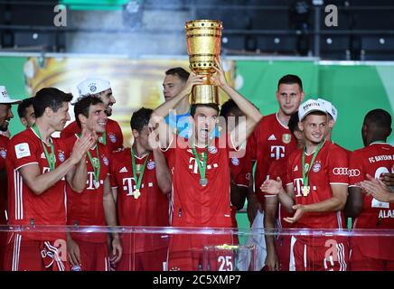 Berlin, Germany, 4 th July 2020,  Celebration winner ceremony: Thomas MUELLER, MÜLLER, FCB 25  with trophy, Leon GORETZKA, FCB 18 Philippe COUTINHO, FCB 10 Thiago ALCANTARA, FCB 6  Javi MARTINEZ, FCB 8 Mickael (Michael) CUISANCE, FCB 11  Robert LEWANDOWSKI, FCB 9 Lucas HERNANDEZ (FCB 21) Alphonso DAVIES, Manuel NEUER, FCB 1 FCB 19  Trainer Hansi FLICK (FCB), team manager, headcoach, coach,  David ALABA, FCB 27 Corentin TOLISSO, FCB 24 Alvaro ODRIOZOLA, FCB 2 Thomas MUELLER, MÜLLER, FCB 25 FCB Co-Trainer Hermann GERLAND,  at the DFB Pokal Final match  FC BAYERN MUENCHEN - BAYER 04 LEVERKUSEN 4- Stock Photo