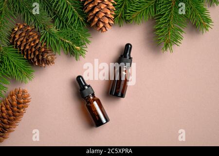 Flat lay composition with bottles of conifer essential oil on neutral table. Natural organic cosmetics for hair care. Stock Photo