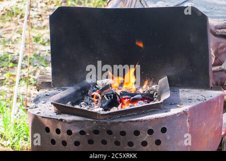 Camping outdoors - tents, equipment and cooking. Cooking at a camping site in nature. Stock Photo