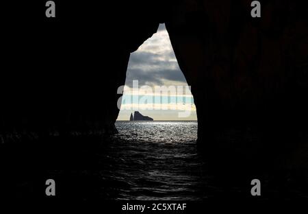 Kicker Rock seen from a cave at sunset near San Cristobal island in the Pacific Ocean, Galapagos national park, Ecuador. Stock Photo