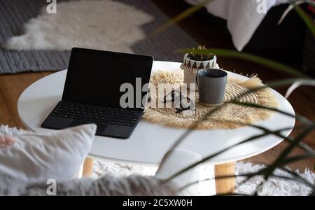 Working from home on laptop at coffee table Stock Photo