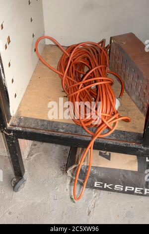 Long orange electrical extension cord coiled and ready for use. Zawady Gmina Rzeczyca Poland Stock Photo
