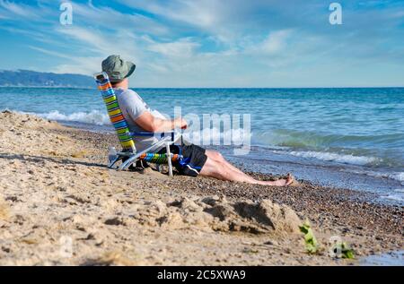 Man relaxing on the beach, enjoying retirement on the shores of Lake Michigan USA Stock Photo