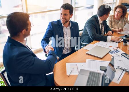 Business lawyers workers meeting at law firm office. Professional executive partners working on finance strategry at the workplace. Shaking hands for