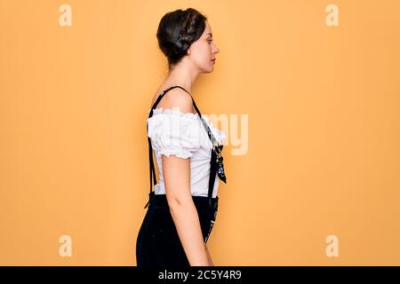 Young beautiful german woman with blue eyes wearing traditional octoberfest dress looking to side, relax profile pose with natural face with confident Stock Photo