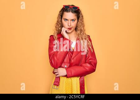 Young beautiful blonde woman pin-up with blue eyes wearing red sunglasses and jacket thinking looking tired and bored with depression problems with cr Stock Photo