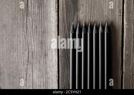 Sharp graphite pencils on wooden background, closeup