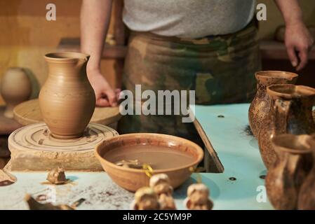 Process of making clay pot on a potter's wheel in workshop. Potter at work Stock Photo