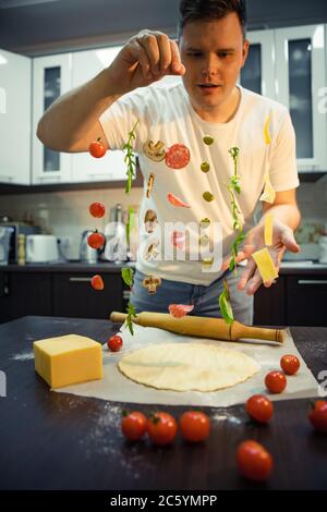 man making pizza ingredients like salami mushrooms olive cheese freeze in air Stock Photo