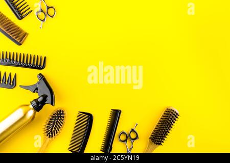 Hairdressing instruments. Combs, scissors on yellow table top view frame copy space Stock Photo