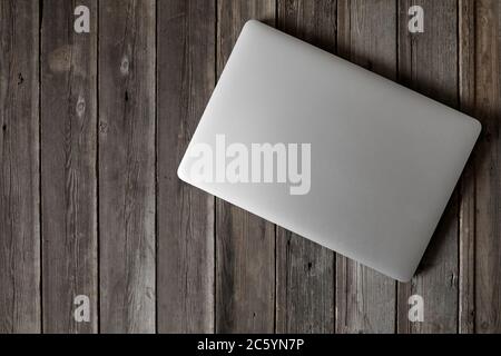 Mock up of blank laptop on the desk. Personal laptop computer on wood table over brick wall background. Stock Photo