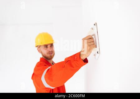 Close up foreman in orange work clothes and yellow hardhat using Stock Photo