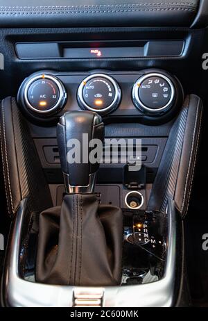 The gear shift of automatic transmission with air conditioning controls on the car dashboard. Focused at gearbox. Stock Photo
