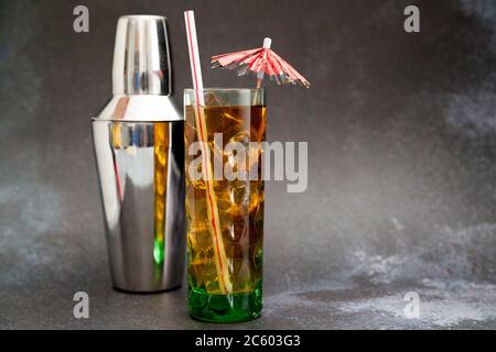 https://l450v.alamy.com/450v/2c603g3/iced-tea-glass-with-umbrella-and-straw-and-cocktail-shaker-on-dark-background-with-copy-space-2c603g3.jpg