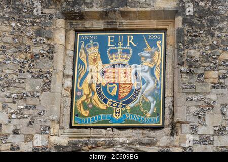 Entrance gate to Winchester Cathedral with coat of arms of Queen Elizabeth II, Hampshire, UK Stock Photo